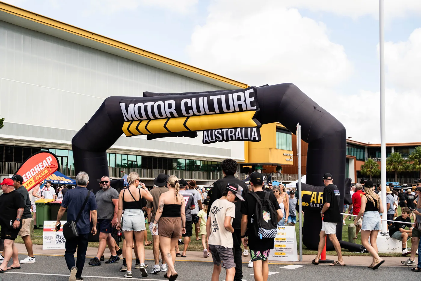 Crowd streaming through the Motor Culture Australia arch at a Cars & Culture event